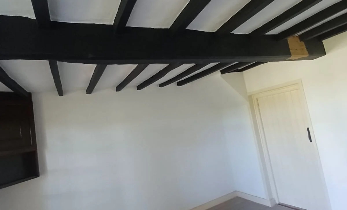 Room with dark ceiling beams before cleaning